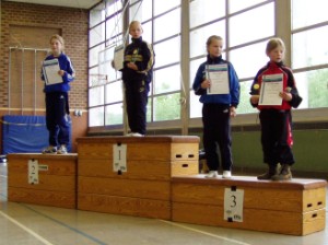 Erste Siegerehrung auf dem Treppchen für den dritten Platz von Daniele Hagedorn. Da gleich zwei Teilnehmerinnen, im Wettkampf auf die Hundertstel gleich bewertet wurden, stehen zwei Teilnehmerinnen auf dem Treppchen. Ein Problem für die Organisatoren.  